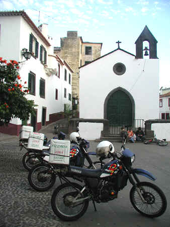 Motorrder einer Pizzeria vor einer Kirche